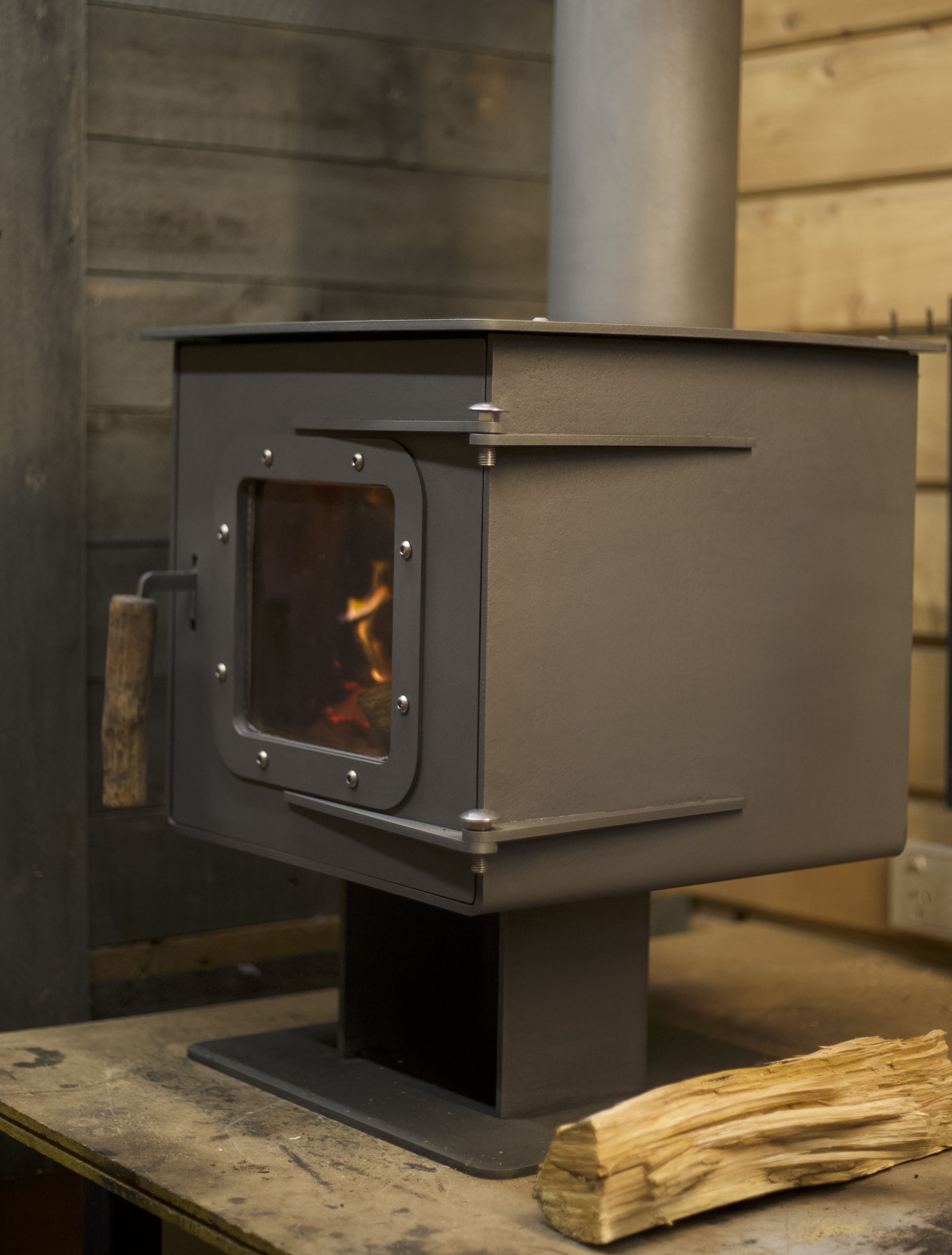 Mukluk Small wood stove with fire glowing through the glass door